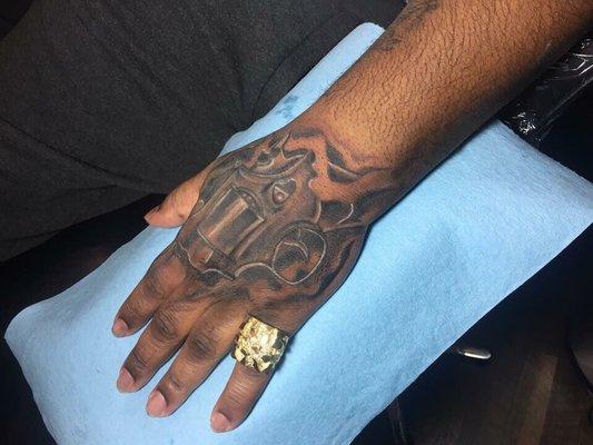 Revolver hand tattoo