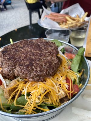 Fresh salad topped with juicy burger!