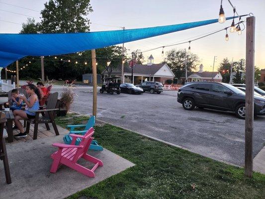 Seating area with shade sail and ambient lighting.