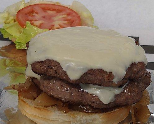 Two beef patties with Lettuce, tomato, mayo, mustard, katchup, grilled onions and cheese on a bun.