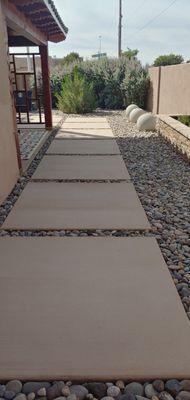 sealed concrete slabs and large river rocks.