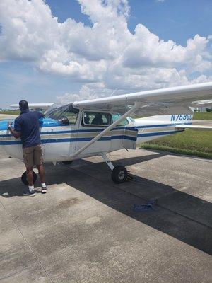 William doing pre-flight checks before my check ride