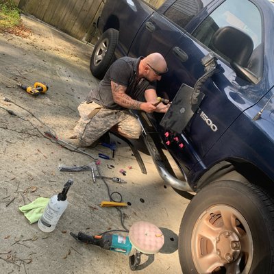 Hard at work performing paint-less dent repair at a customers home.