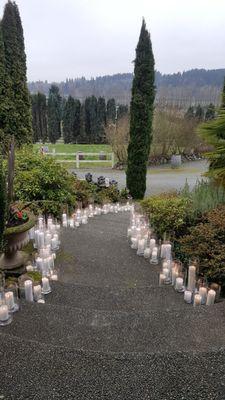 This walkway is decorated with real candles for a wedding.