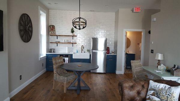 Full fridge with ice maker, coffee maker, microwave, toaster, and dining area.