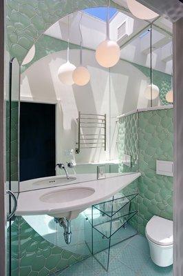 Glass tile, mirrors and skylights expand space and light in this San Francisco bathroom remodel.