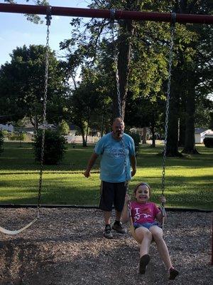 Father and daughter swinging