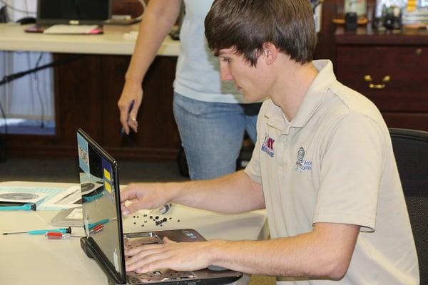 Our service tech, Tyler, working on a laptop