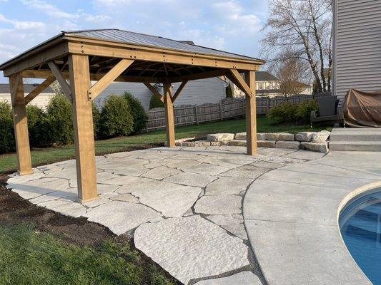 Flagstone patio with outcropping retaining wall at end of pool deck