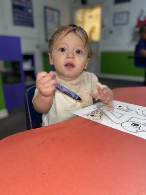 My child learning to hold crayons and color.