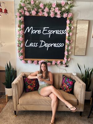 Me in front of the sign with my coffee