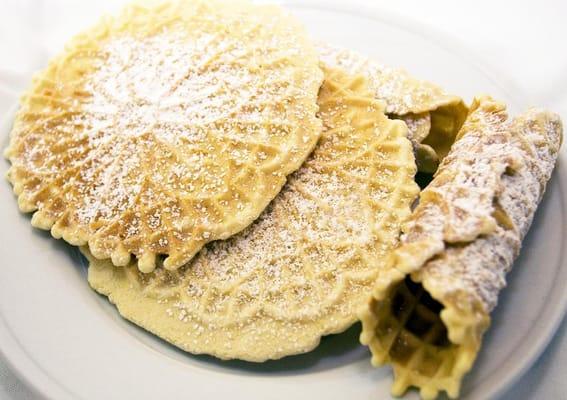 Traditional Italian Pizzelle with a deep anise flavor and sprinkled with powdered sugar.