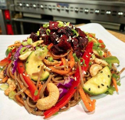 Just Beet It Soba noodle salad mixed with peppers, carrots, zucchini, green onion, beets, and served with sesame ginger dressing.