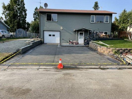 Concrete Driveway Exposed Aggregate plus sealed also a Retaining Block Wall.  Stamped border concrete on driveway.