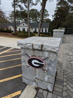 Outside. Entrance columns with UGA Golf logo. View from parking lot.