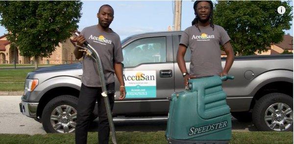 Accusan staff with cleaning equipment and vehicle in the background