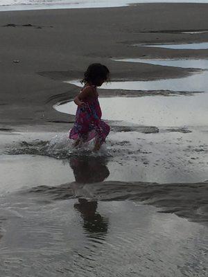 Daughter walking the beach during high tide