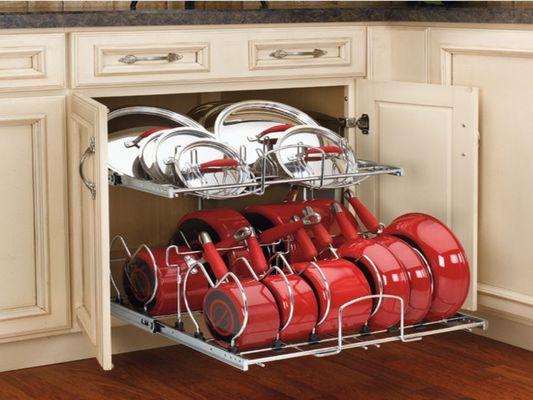 Glide-out shelves designed for pans and pots offer a practical solution for organizing and maximizing storage space in a kitchen.