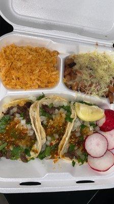 Rice, beans , cheese, tacos, asada, raddish,  lemon .