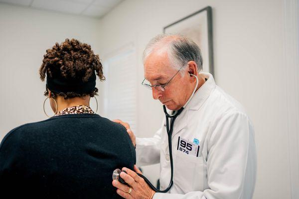 Dr. Durham listening to patient with stethoscope