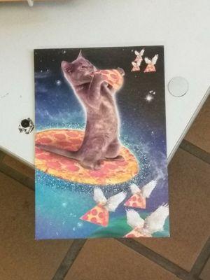 Grey manx kitty cat space-cadet on a pepperoni pizza saucer  eating a slice of pizza in outer space with winged pizza slices. By Hallmark.