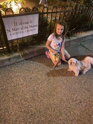 My daughter and dog posed in front of our church during a summer walk