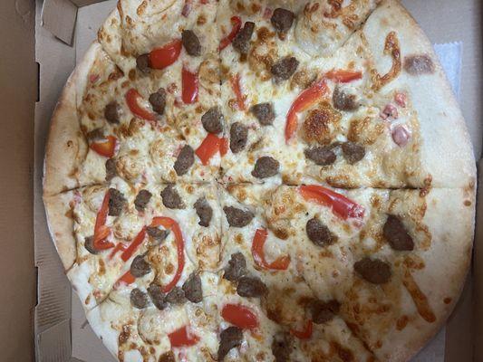 Alfredo pizza with sausage and red pepper.