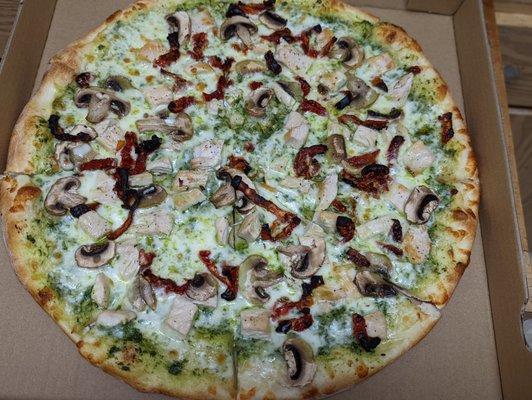 Pesto Pizza with chicken breast, sundried tomatoes, and onions.