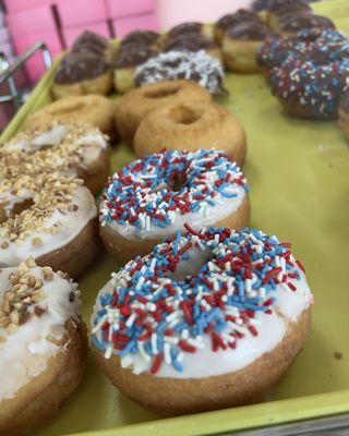 Frosted cake donuts with nuts and sprinkles