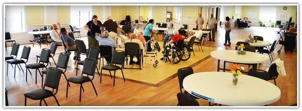 Members doing a group stretching activity with staff on a typical day at Shanti Gardens Adult Day Care.