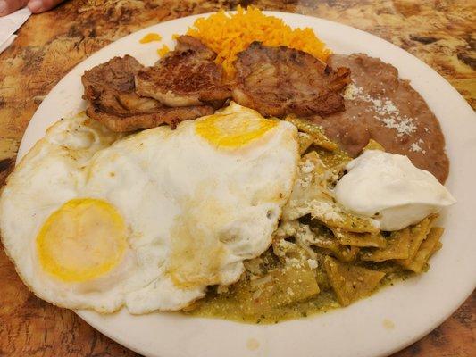 Chilaquiles verdes, huevos, steak, rice and beans.