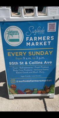 Sandwich sign along beach walk advertising the Surfside Farmer's Market every Sunday 9am-3pm. Photo taken April 2022