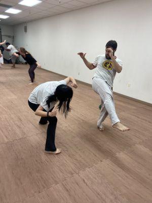 Beginner Capoeira student learning a basic dodge.