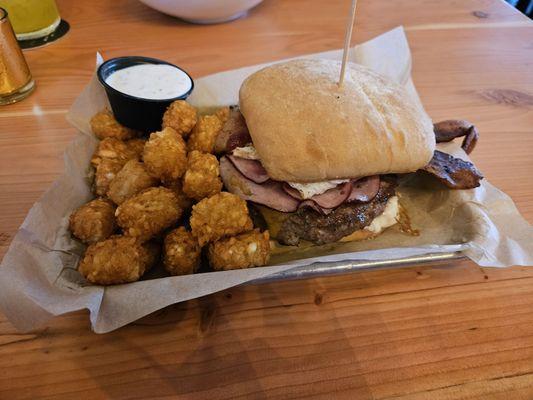 Burger with everything on it and tots.