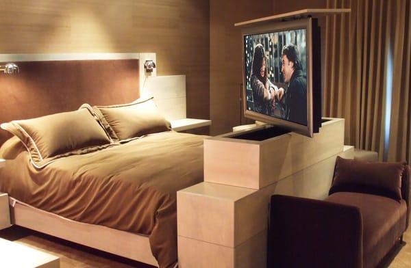 A flat screen TV on a lift hidden in the master bed.