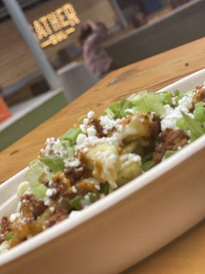 Loaded Chorizo Fries, with goat cheese, Red pepper and pistachio Romesco sauce, Buttermilk Herb Ranch, and Arugula.