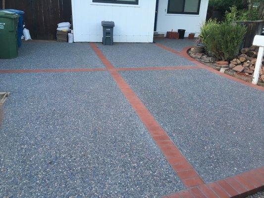 Concrete aggregate driveway combined with Mexican pebbles outlined with brick