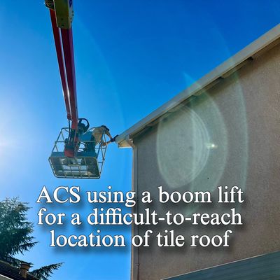 The ACS Roofing team going "above and beyond" using a boom lift to access a different-to-reach area of a roof on a recent repair.