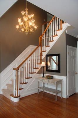 So many people shy away from dark colors. In the great expanse of this front hall, A darker, warm gray cozies the space witho...