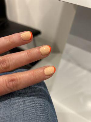 Regular French manicure with pale peach base color and neon orange tips.