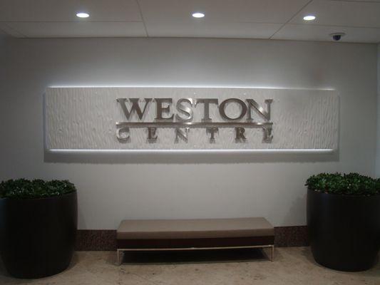 Dimensional stainless letters mounted on sculpted background with background LED lighting.