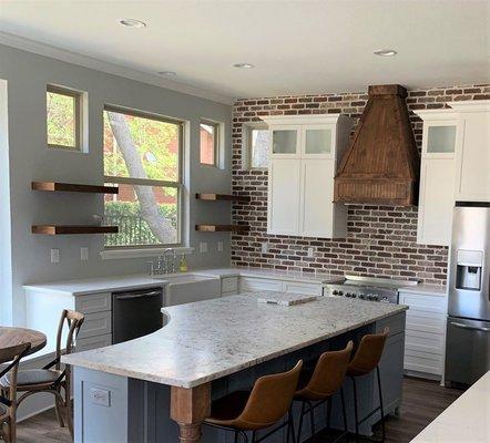 Leathered White Ice granite was installed on the island, and Carrera White Quartz on the outer countertops.