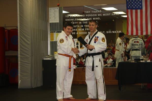 Jack receiving his black belt from Mr. Johnson!