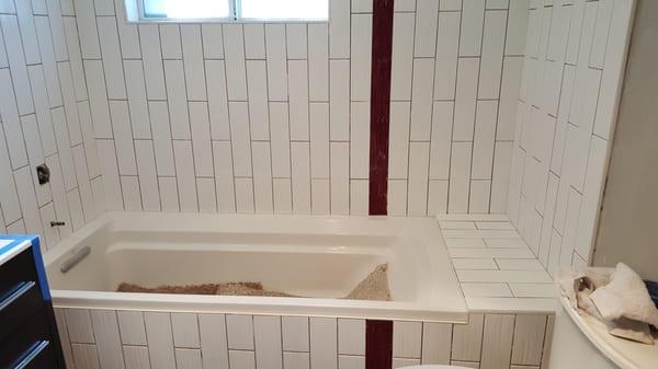 3" x 12" custom tub tile enclosure with accent mosaic stripe.