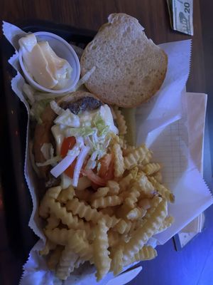 Cheeseburger with lettuce tomatoes and onions, and fries.