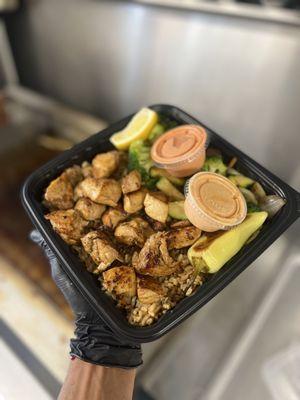 Chicken served with fried rice and grill vegetables.