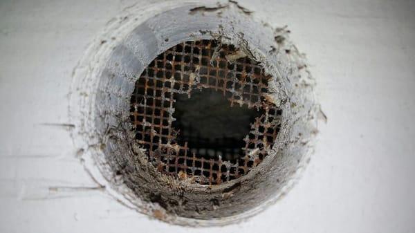 Breather hole screen  under eaves that's been rusted and deteriorated.