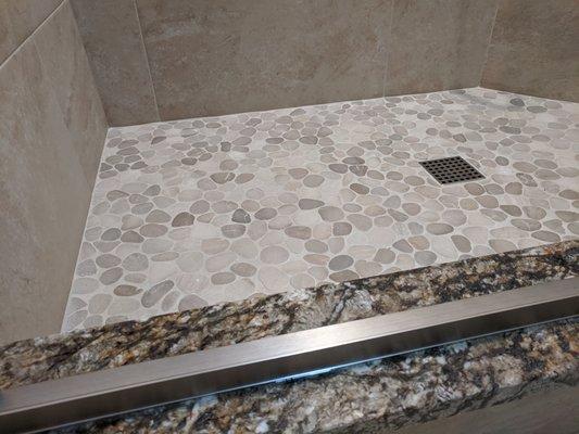 Split pebble floor tile on shower floor