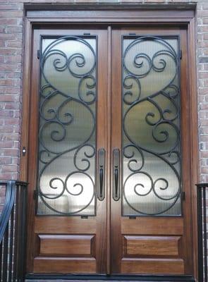 to a double 8 foot mahogany doors, with  reeded glass, decorative wrought iron and the door is stained **we are a distributor...