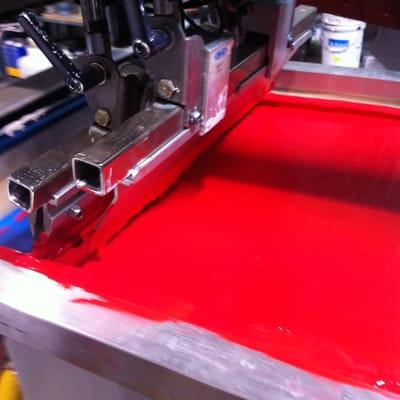 A flooded screen with Red ink about to print on a t shirt